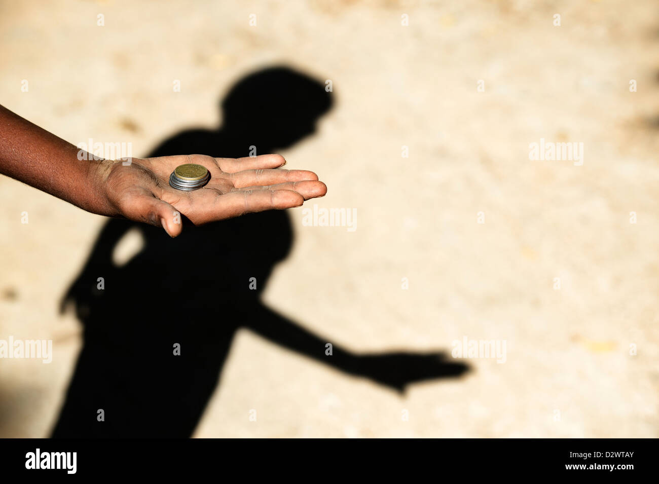 Armen indischen Childs Hand ausgestreckt halten Rupie Münzen und Schatten betteln. Indien. Selektiven Fokus mit Textfreiraum Stockfoto