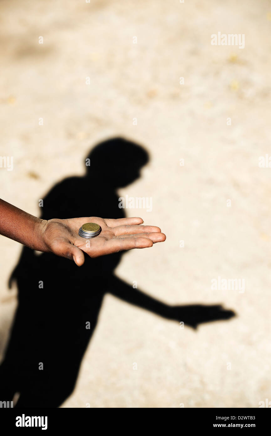 Armen indischen Childs Hand ausgestreckt halten Rupie Münzen und Schatten betteln. Indien Stockfoto