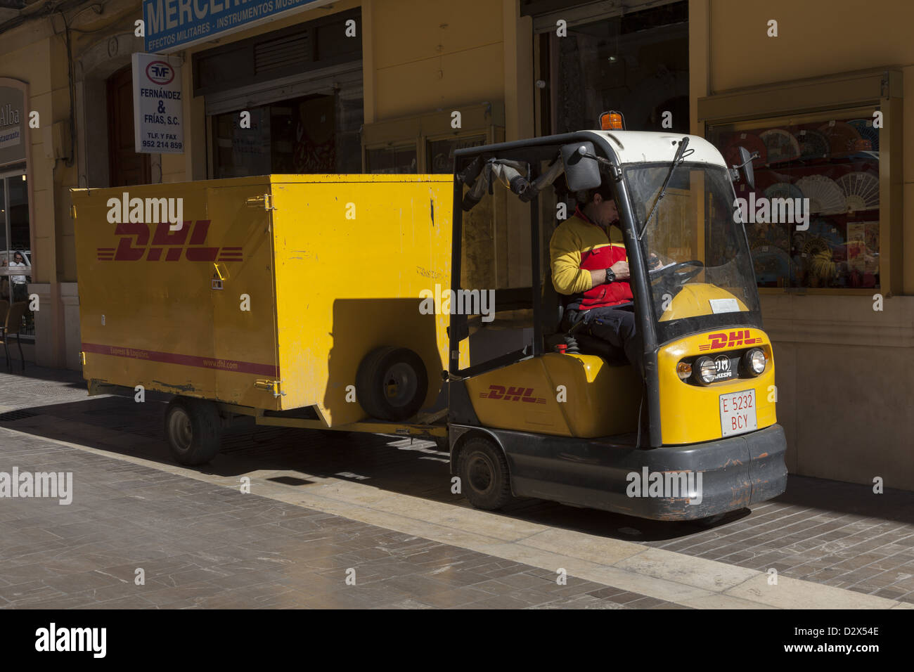 Miniatur DHL drei Rädern Lieferung Fahrzeug abschleppen Cargo trailer Malaga Costa del Sol, Südspanien. Stockfoto