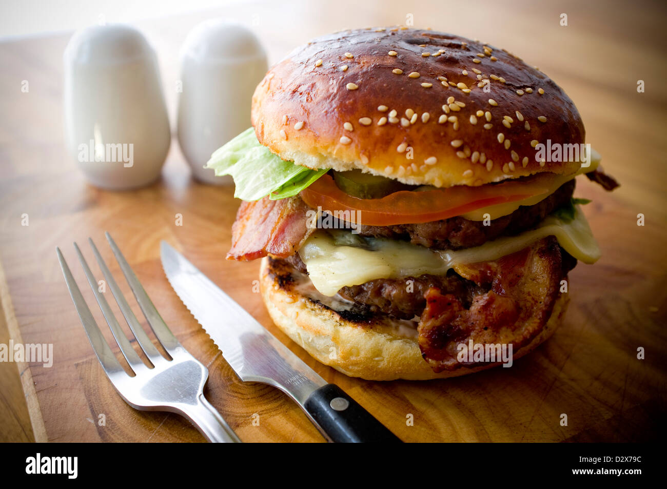 Doppel-Käse - zwei Burger, geschichtet mit Käse, Speck, Tomaten, Salat, Gurke, Zwiebel und Burger-Sauce Stockfoto