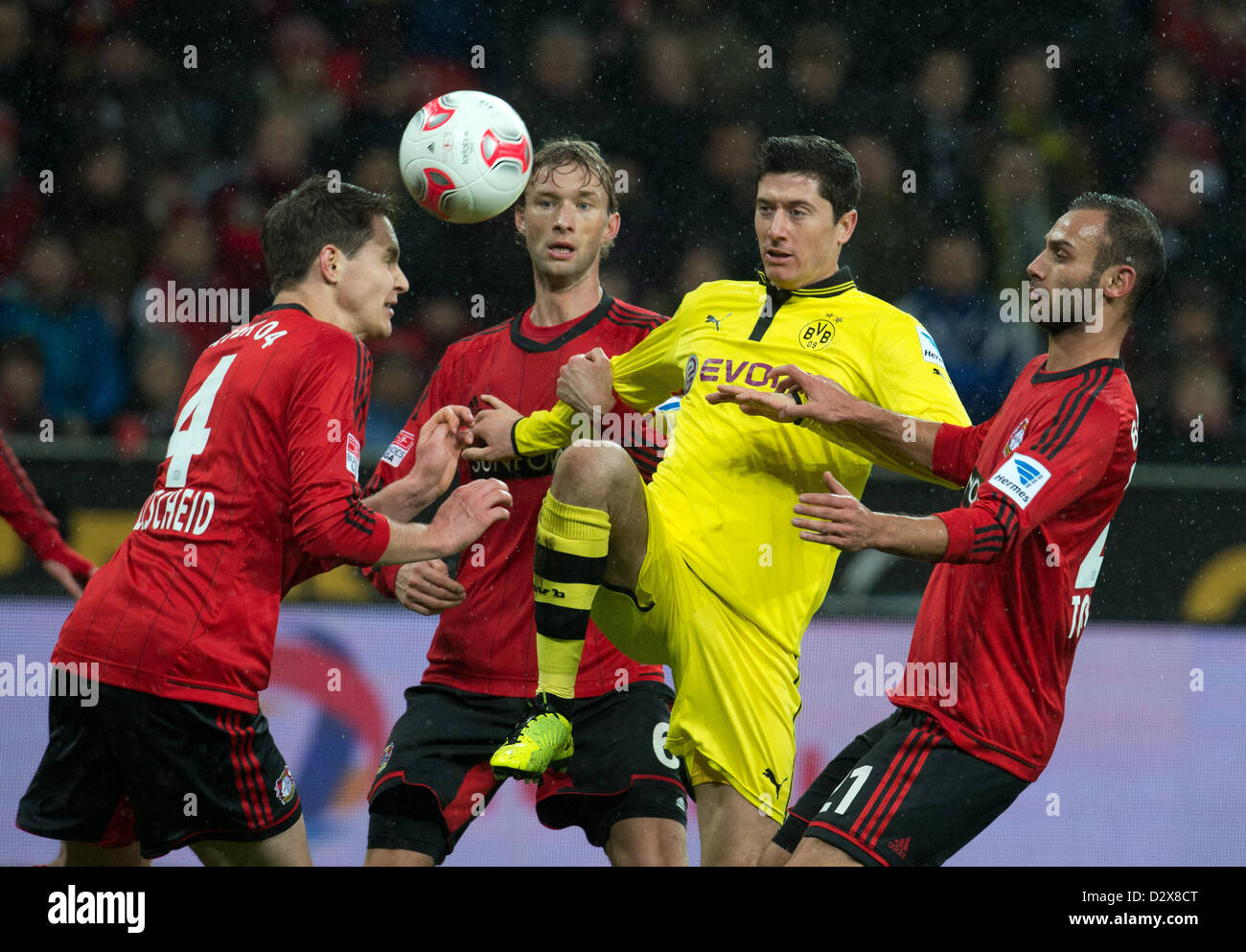 03.02.2013. Leverkusen, Deutschland.  Leverkusens Philipp Wollscheid (L-R), Simon Rolfes und Omer Toprak wetteifern um den Ball mit der Dortmunder Robert Lewandowski (M) in der deutschen Bundesliga-Fußballspiel zwischen Bayer Leverkusen und Borussia Dortmund in der BayArena in Leverkusen, Deutschland. Stockfoto