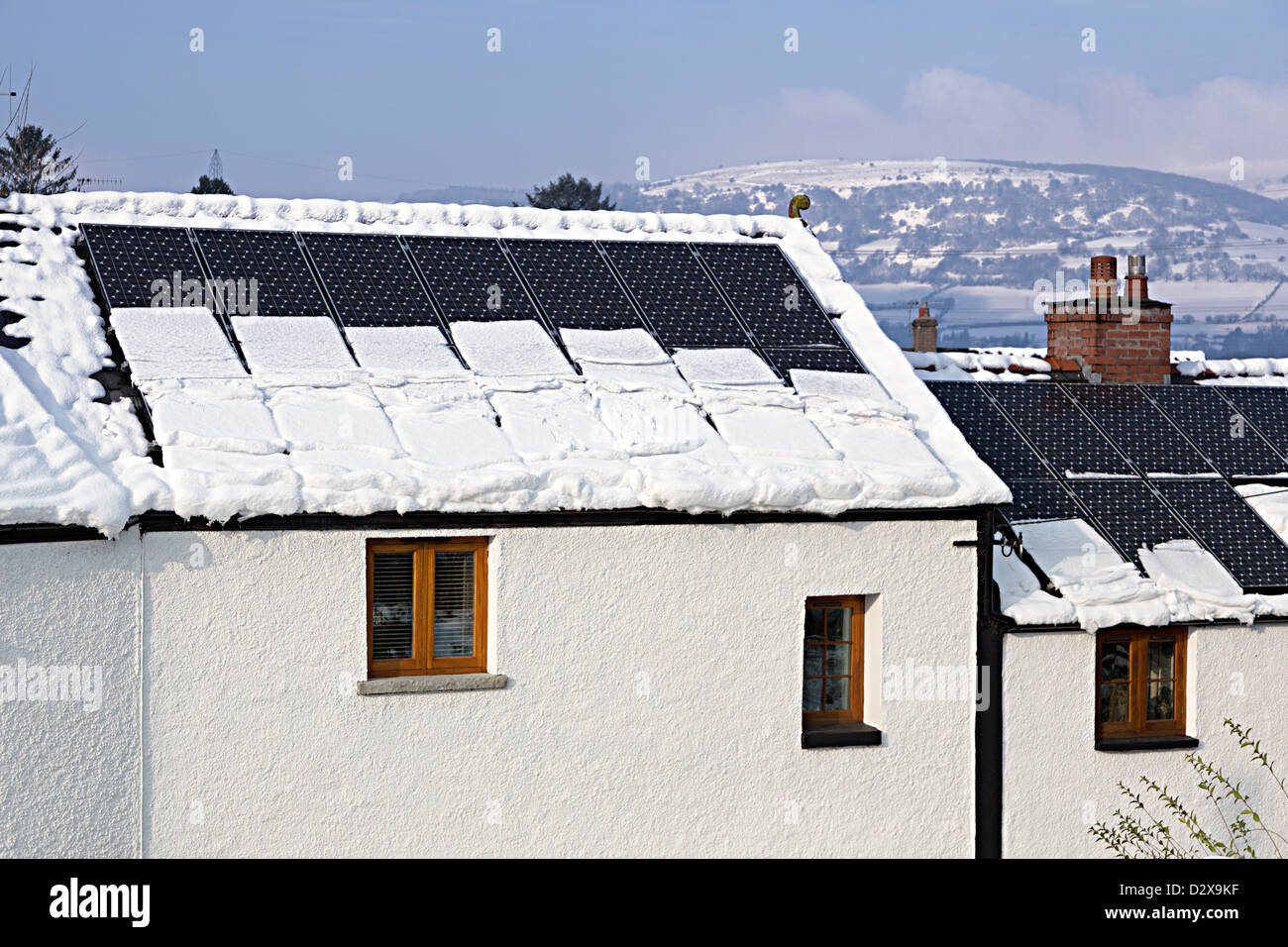 Schnee Abrutschen solar PV-Paneele und Gewichtung auf Dachrinnen Haus, Llanfoist, Wales, UK Stockfoto
