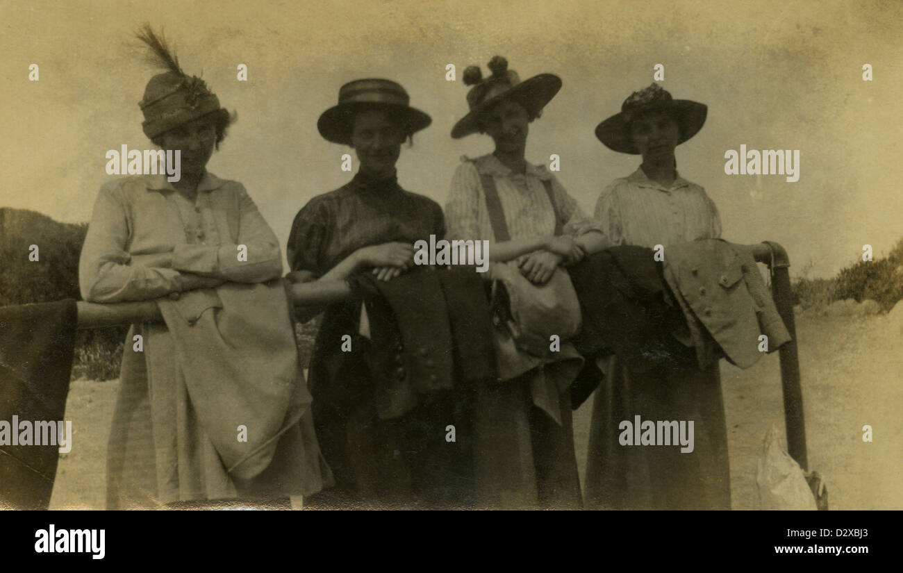 Ca. 1910er Jahre Foto Kleid vier Frauen in der Periode stützte sich auf eine Hitching Post oder Bahn. Stockfoto