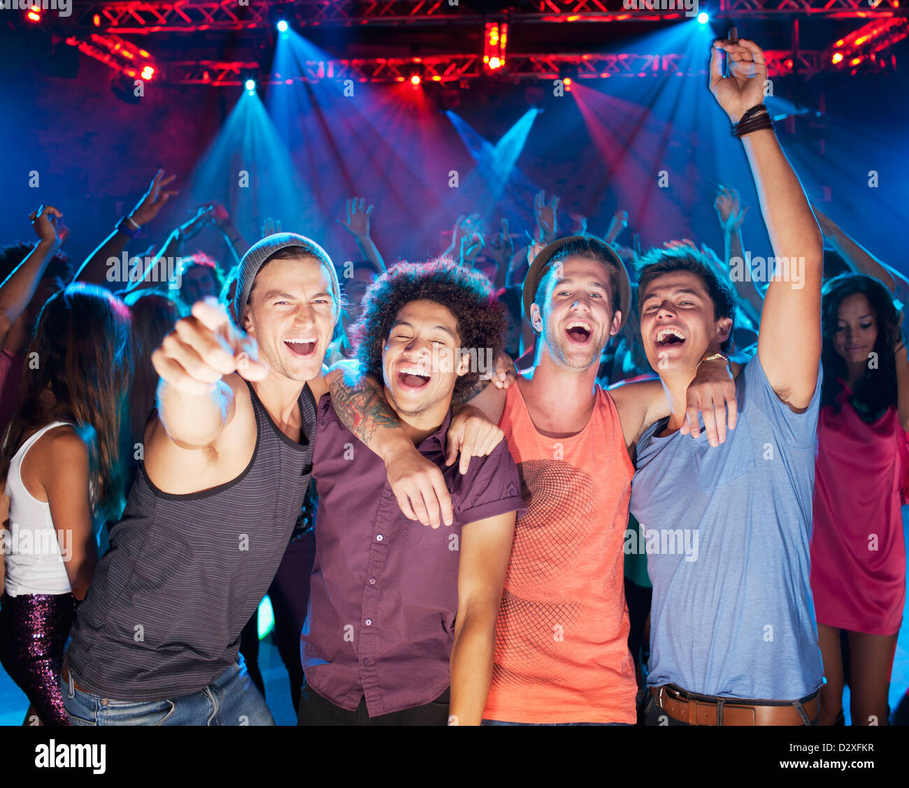 Begeisterte Freunde jubeln auf der Tanzfläche der Disco Stockfoto