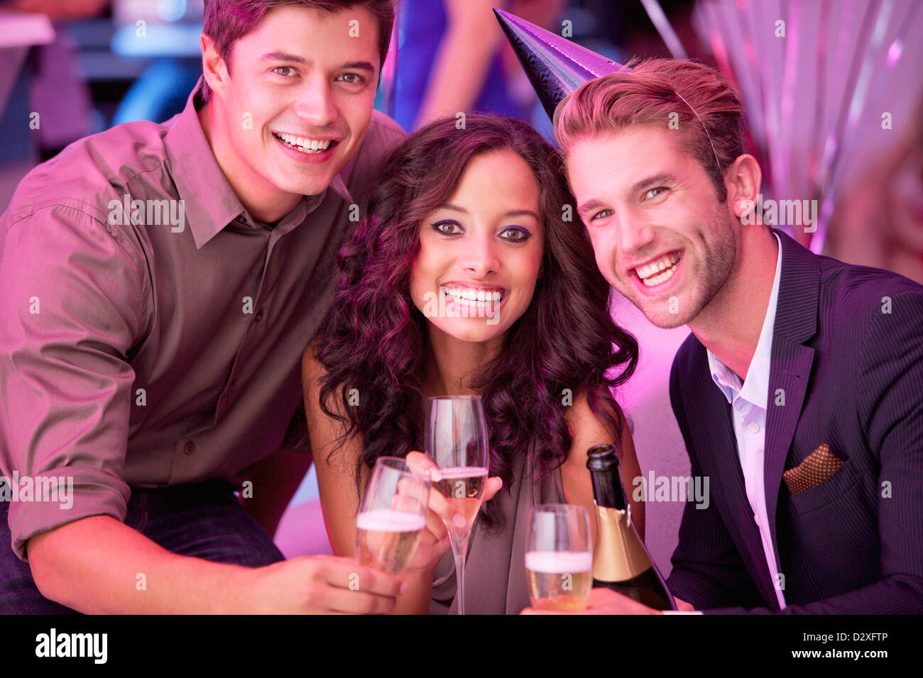 Porträt von lächelnden Freunde trinken Champagner in Nachtclub Stockfoto