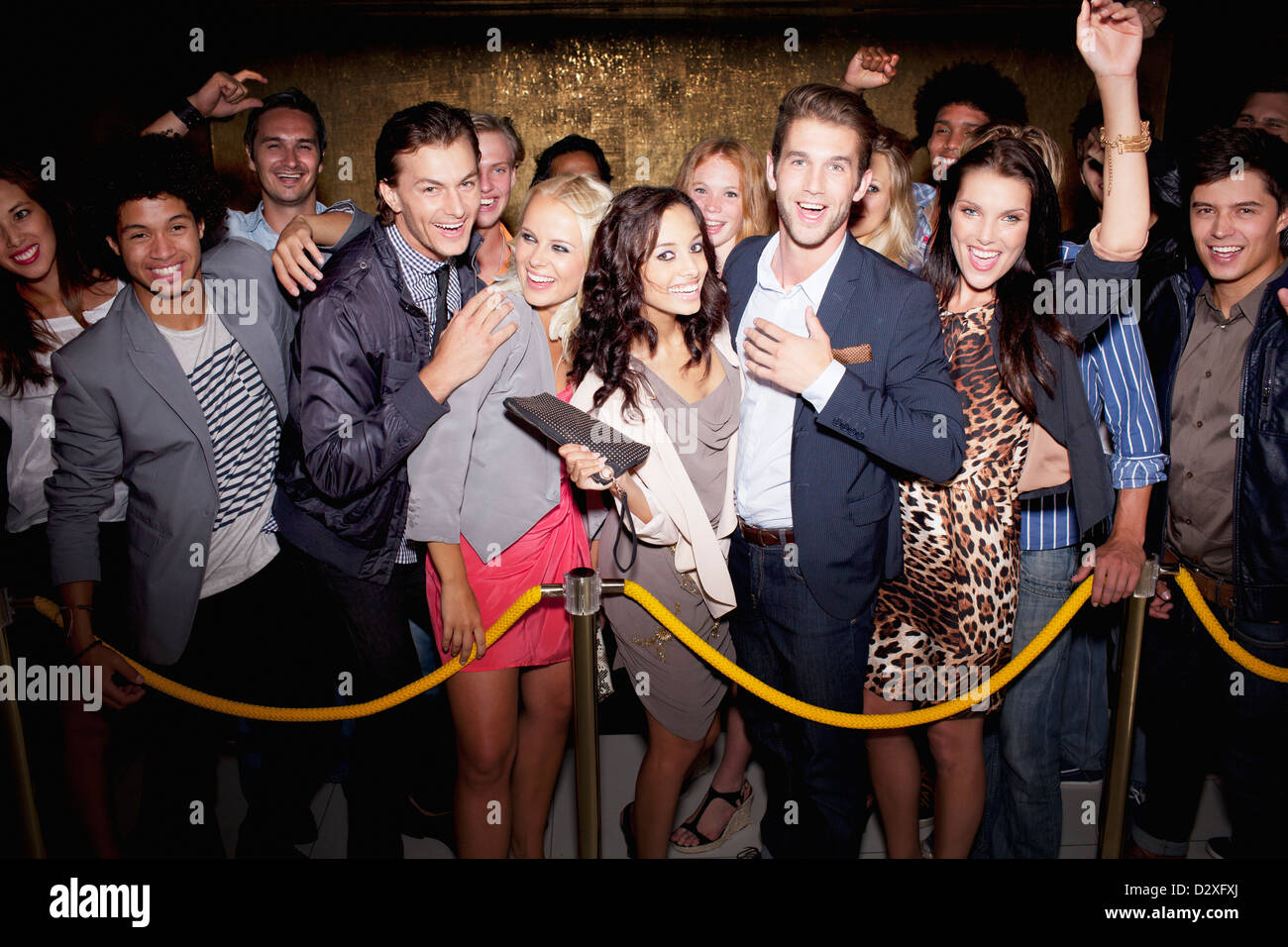 Porträt der begeisterten Menge in Warteschlange vor Nachtclub Stockfoto