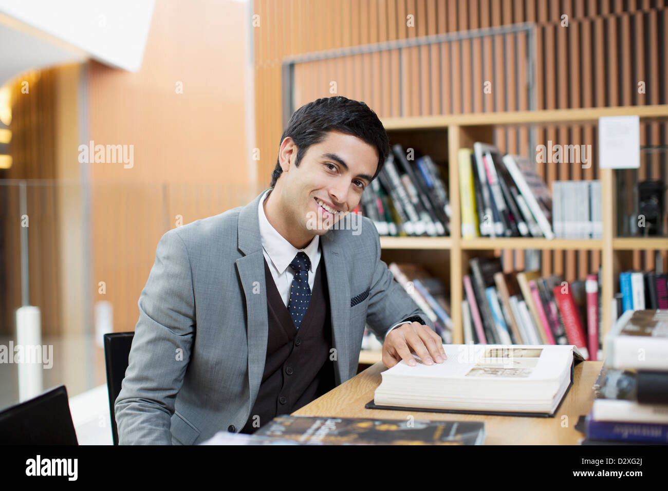 Porträt des Lächelns Geschäftsmann Lesebuch in Bibliothek Stockfoto