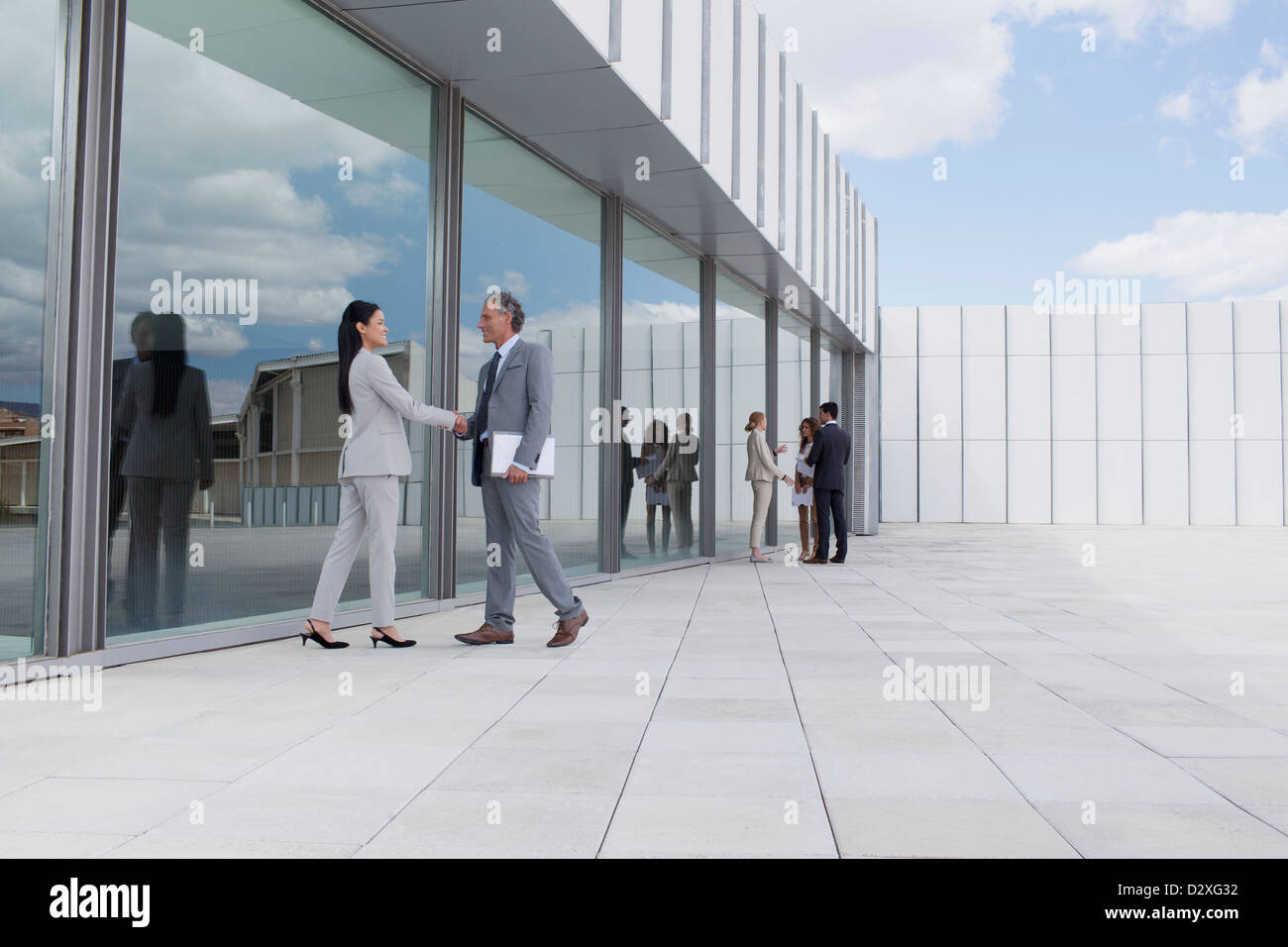 Unternehmer und Unternehmerin Händeschütteln vor Gebäude Stockfoto