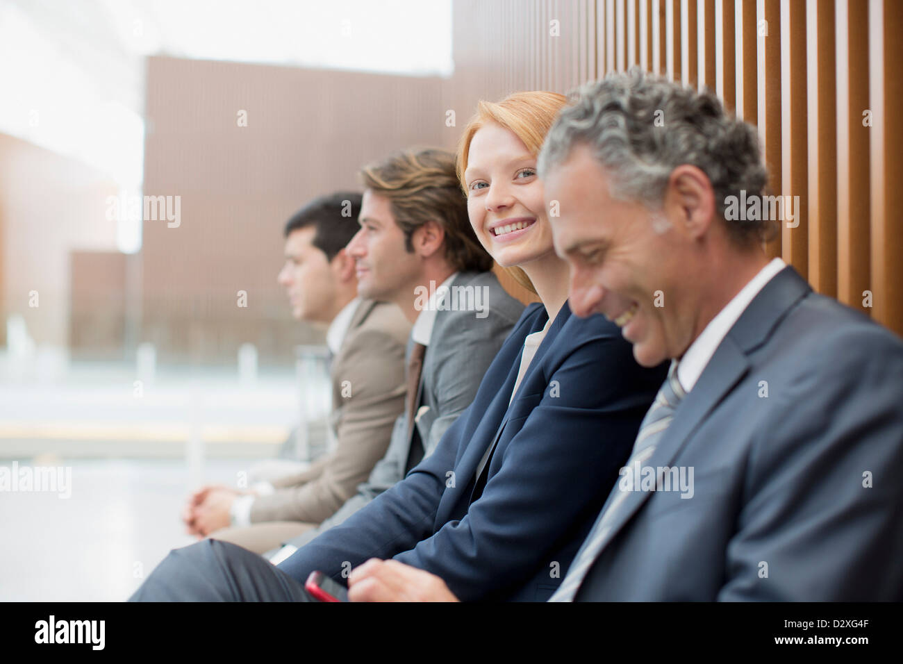 Porträt von lächelnden Geschäftsfrau mit Geschäftsleute sitzen Stockfoto