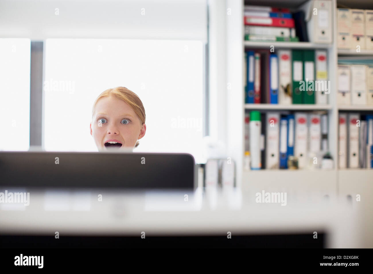 Überrascht, Geschäftsfrau, Lesen von e-Mails am Computer im Büro Stockfoto