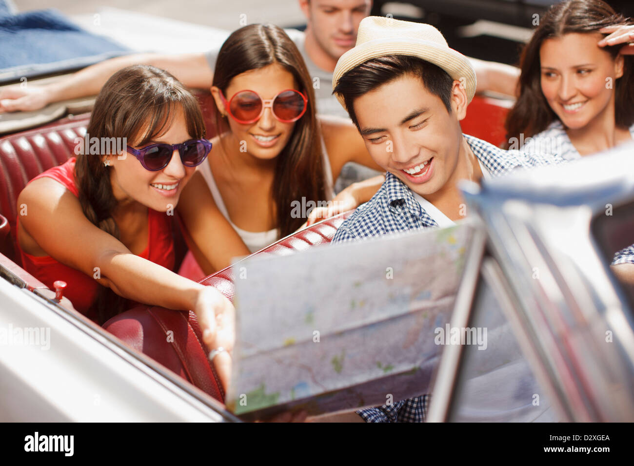 Freunde lesen Straßenkarte im Cabrio Stockfoto