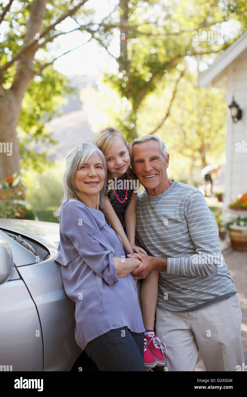 Älteres Paar und Enkelin stützte sich auf Auto Stockfoto