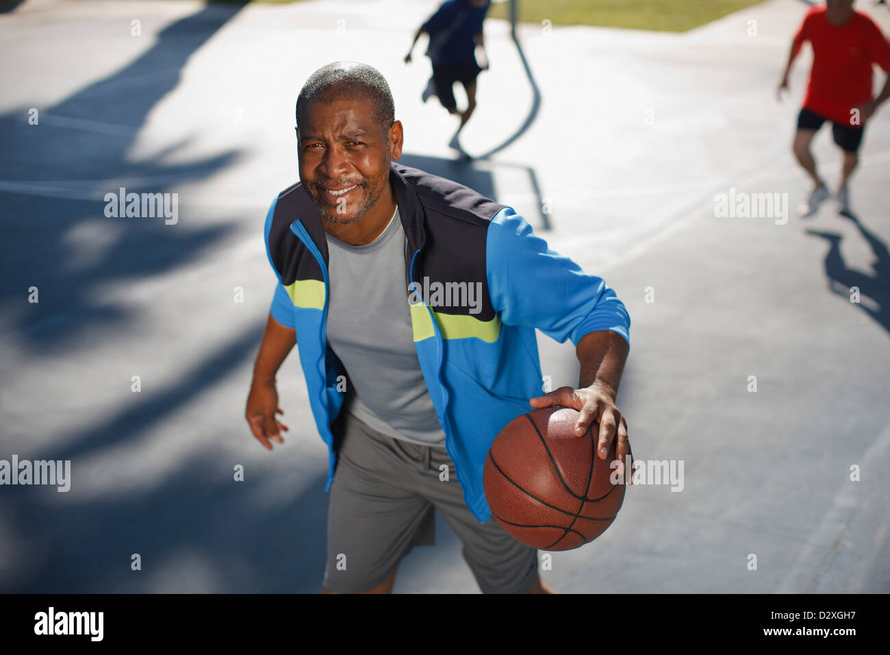 Älterer Mann spielen Basketball auf Platz Stockfoto