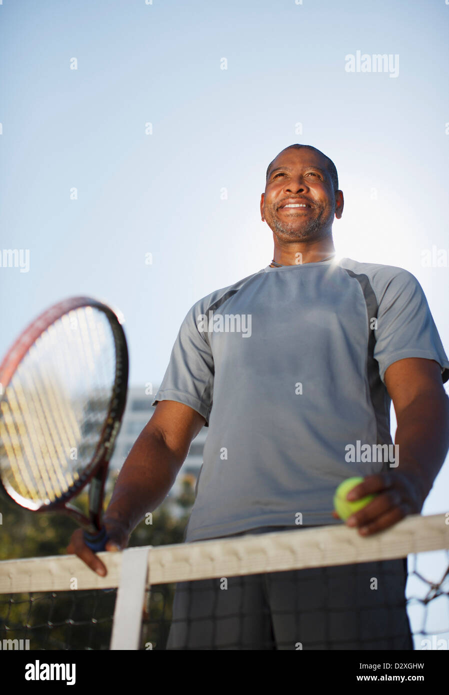 Älterer Mann mit dem Tennisspielen auf Platz Stockfoto