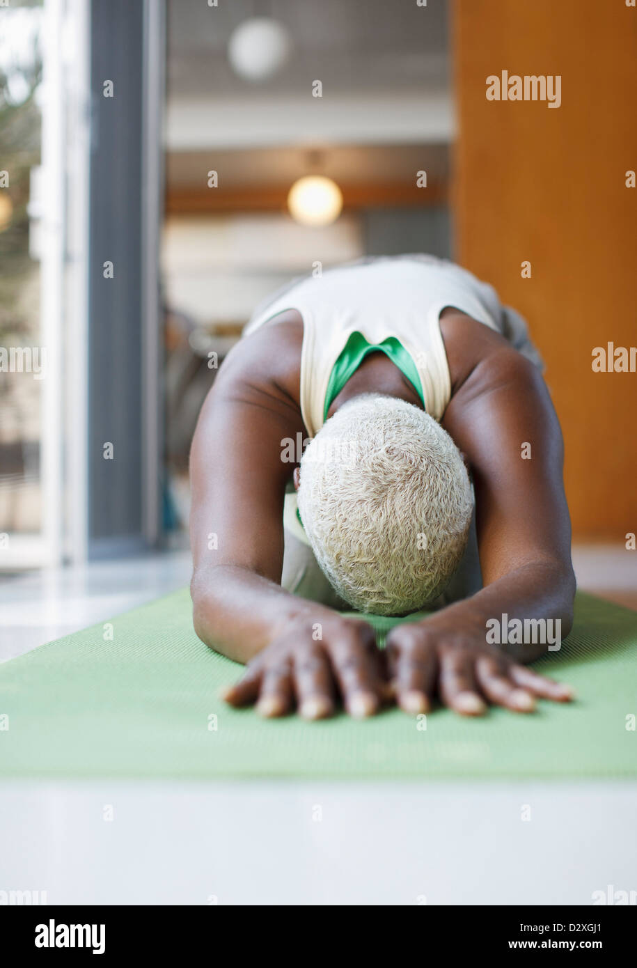 Ältere Frau praktizieren Yoga im Wohnzimmer Stockfoto