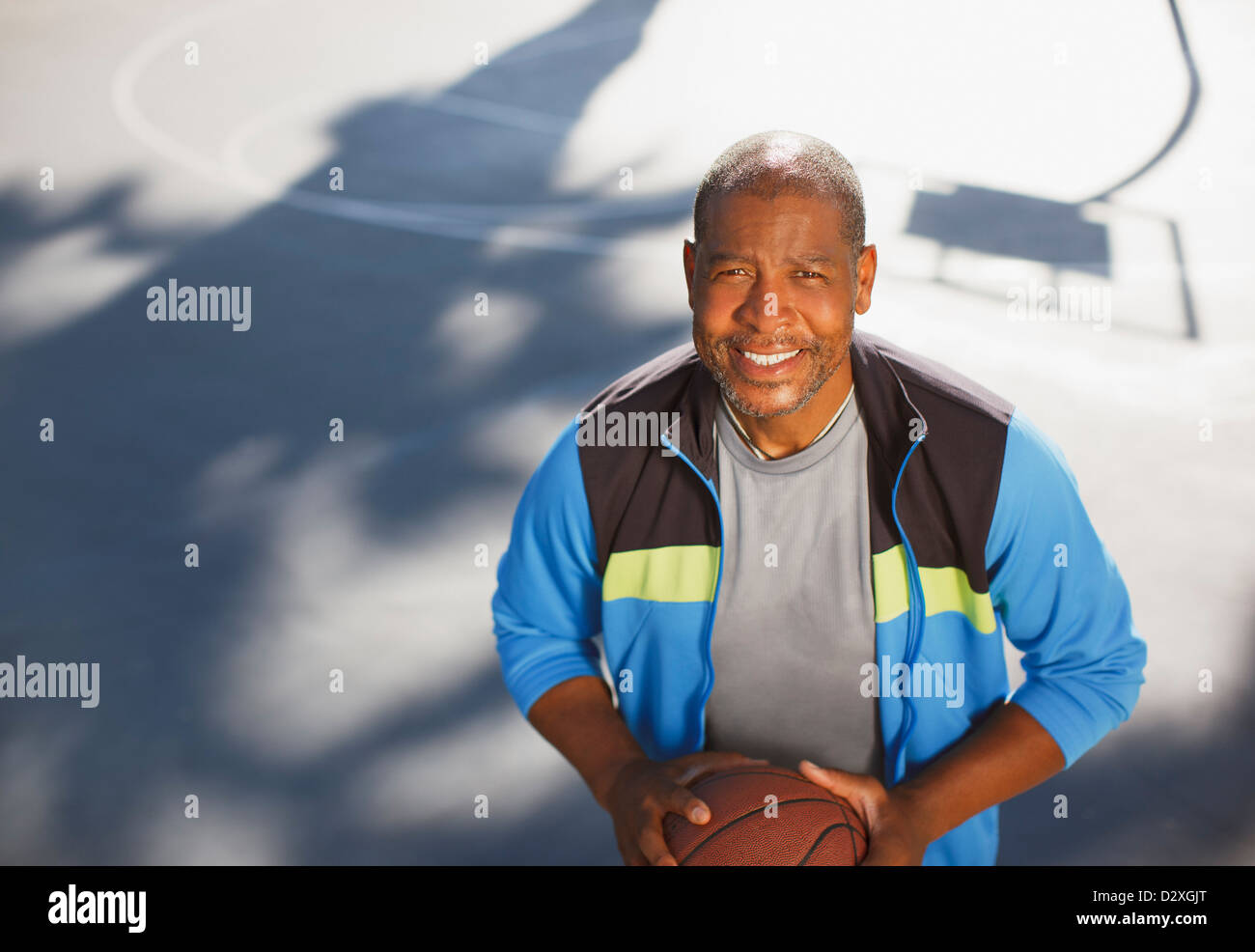 Älterer Mann spielen Basketball auf Platz Stockfoto