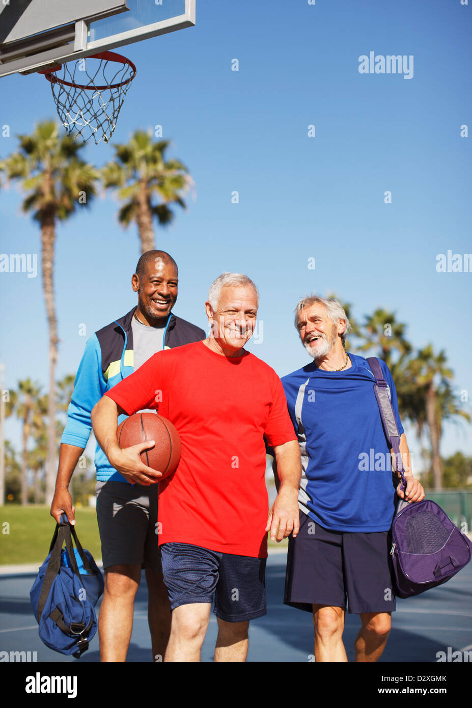 Ältere Männer spielen Basketball auf Platz Stockfoto