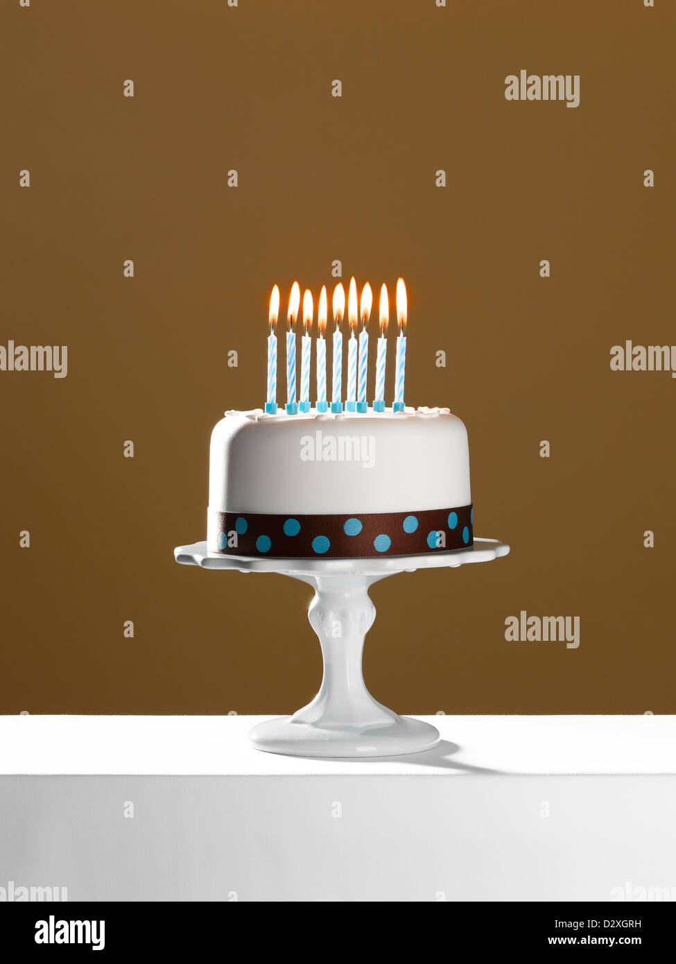 Geburtstagstorte mit brennenden Kerzen auf Kuchen stehen Stockfoto