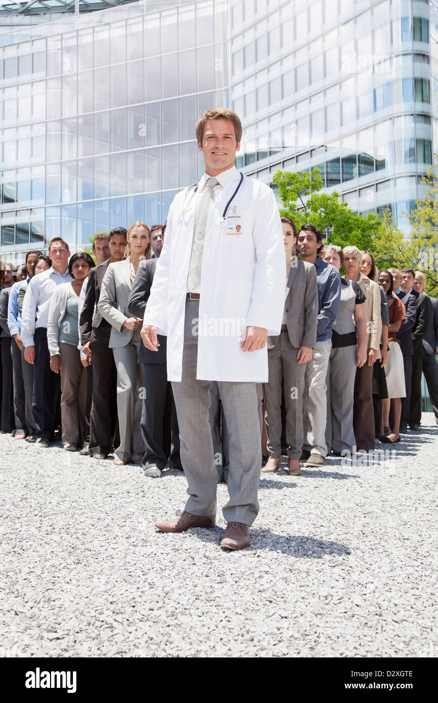 Porträt von lächelnden Arzt mit Geschäftsleuten im Hintergrund Stockfoto
