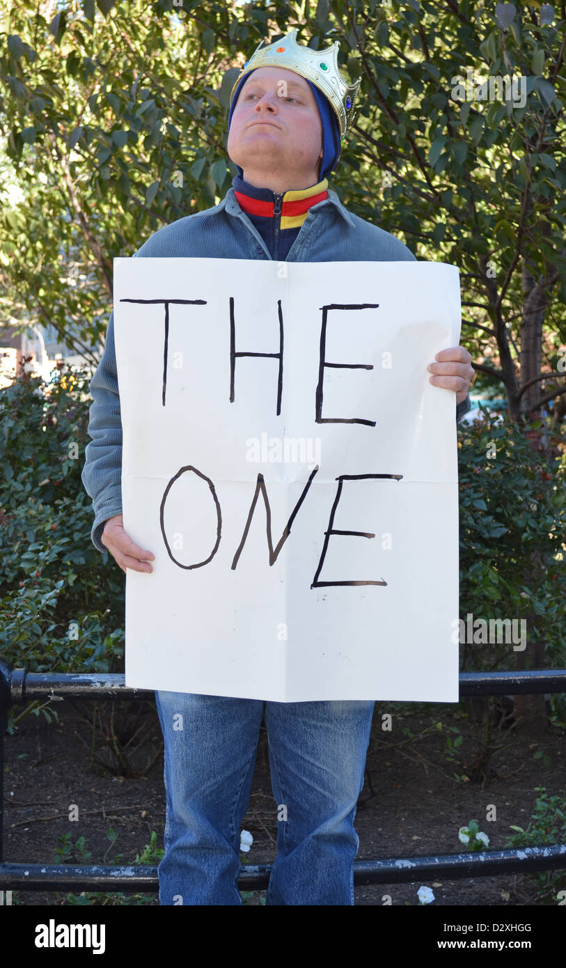 Performance-Künstlerin trägt eine Krone und hält ein Schild mit der Aufschrift "The One" in Union Square Park in New York City Stockfoto