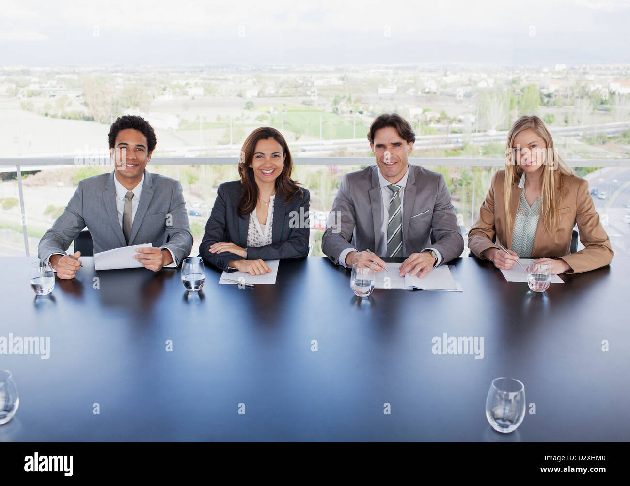 Porträt des Lächelns Geschäftsleute sitzen am Tisch im Konferenzraum Stockfoto