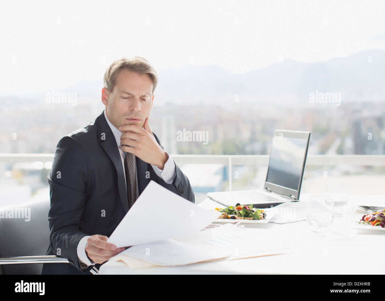 Geschäftsmann mit Mittagessen Überprüfung Papierkram Stockfoto