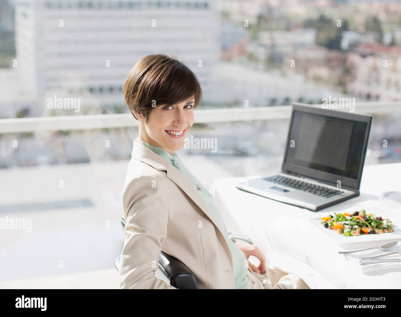 Porträt von lächelnden Geschäftsfrau mit Mittagessen am Schreibtisch Stockfoto