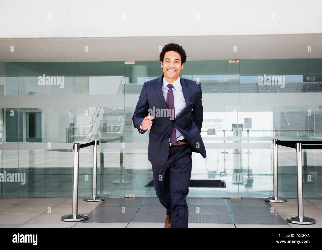 Porträt von lächelnden Geschäftsmann laufen vor dem Flughafen Stockfoto