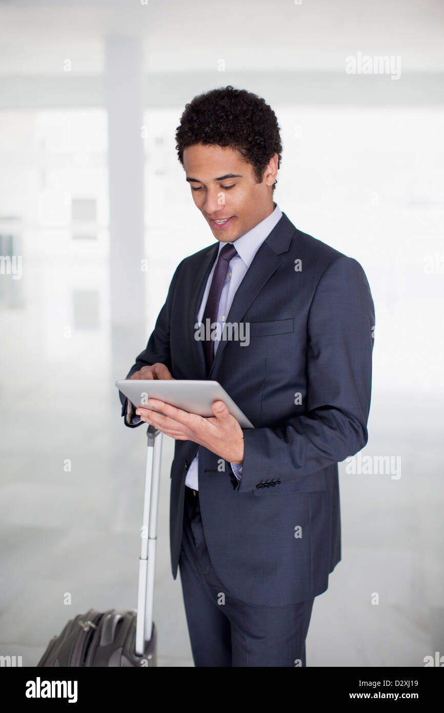 Geschäftsmann mit Koffer mit digital-Tablette in Flughafen Stockfoto