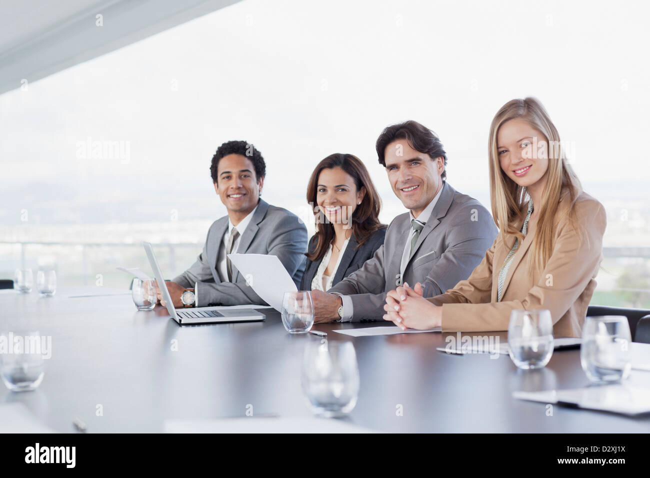 Porträt des Lächelns Geschäftsleute sitzen in einer Reihe im Konferenzraum Stockfoto