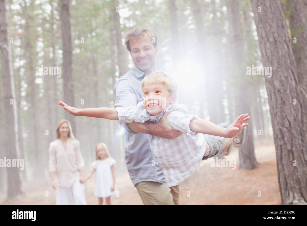 Fliegende Sohn Vater im sonnigen Wald Stockfoto