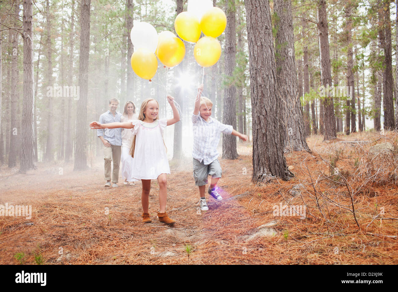 Glückliche Familie mit Luftballons in Wäldern Stockfoto