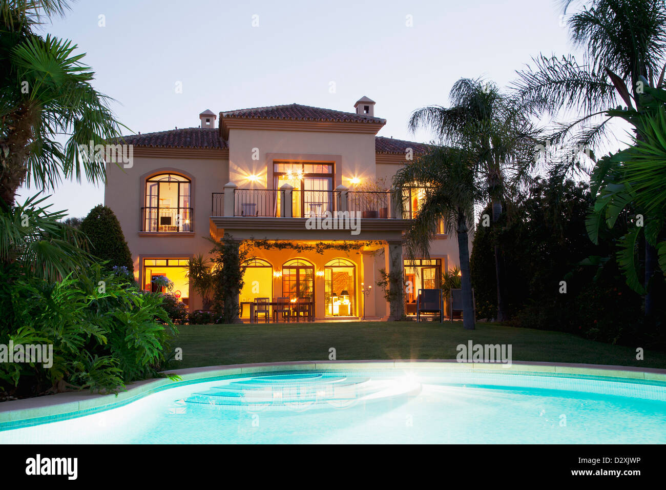 Luxus-Schwimmbad und Villa nachts beleuchtet Stockfoto