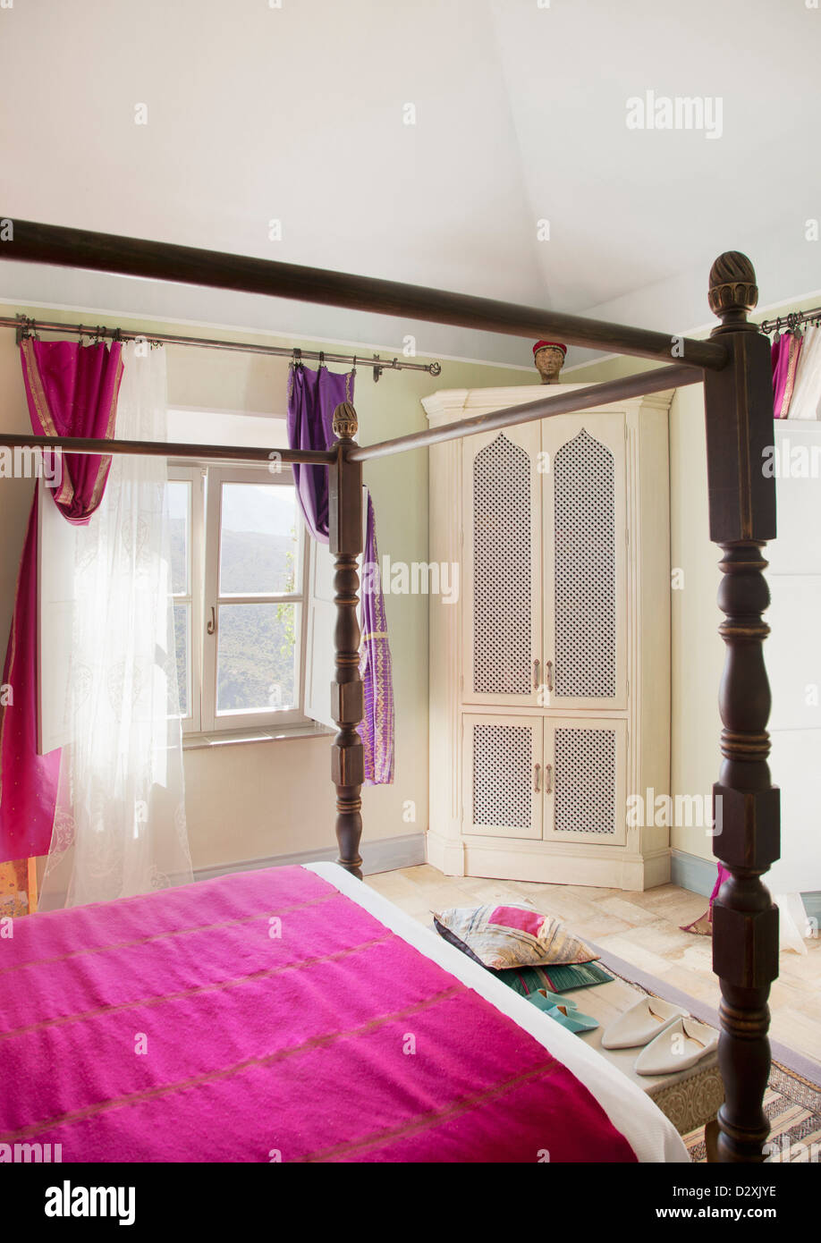 Himmelbett mit lila Bettwäsche im Schlafzimmer Stockfoto