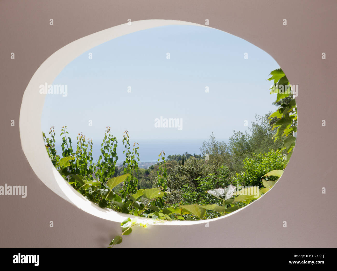Blick auf Garten durch ovale Fenster Stockfoto Blick auf Garten durch ovale Fenster Stockfoto