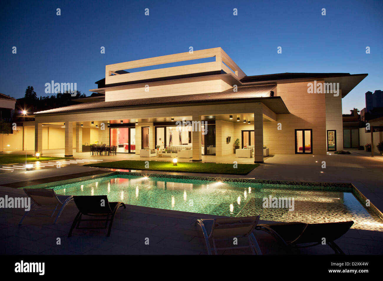Luxus-Haus und Schwimmbad bei Nacht beleuchtet Stockfoto