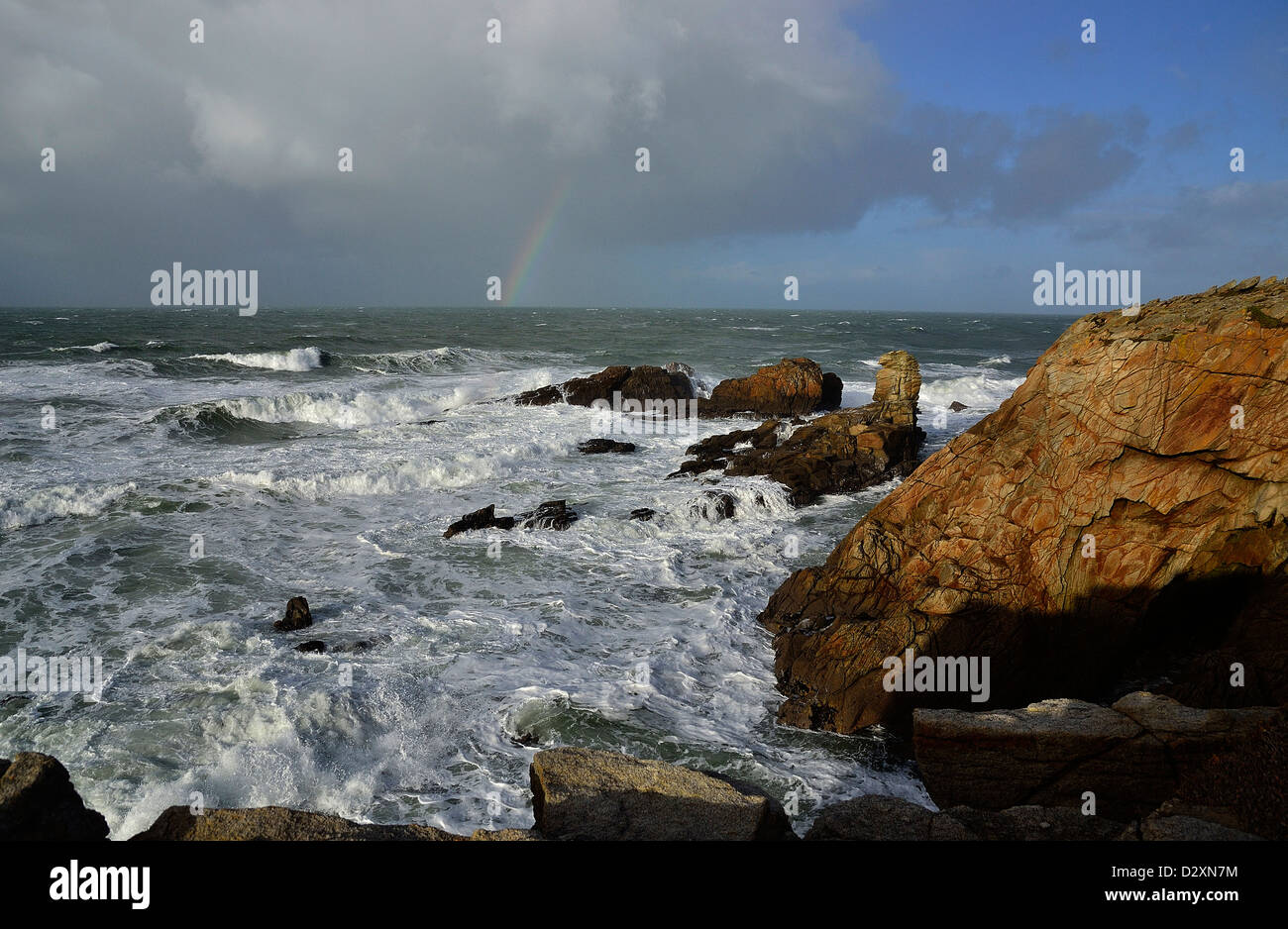 Starker Wellengang im Begriff Beg En Aud, mit einem Regenbogen auf dem Meer, wilde Küste von Quiberon-Halbinsel (Bretagne, Frankreich). Stockfoto