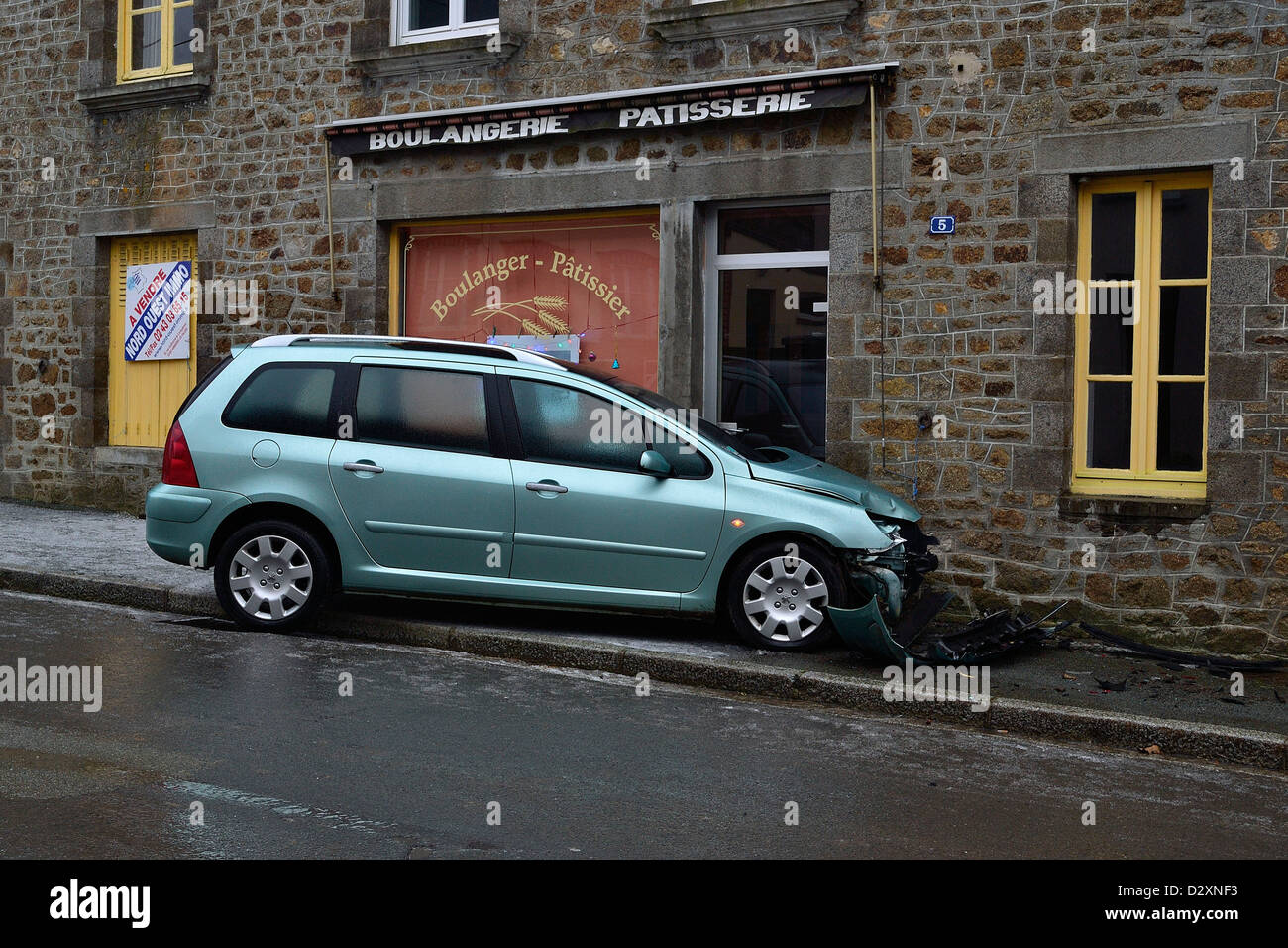 Kufe eines Autos auf der eisigen Straße, das Auto seine Rennen auf einem Haus des Dorfes, im Winter. Stockfoto