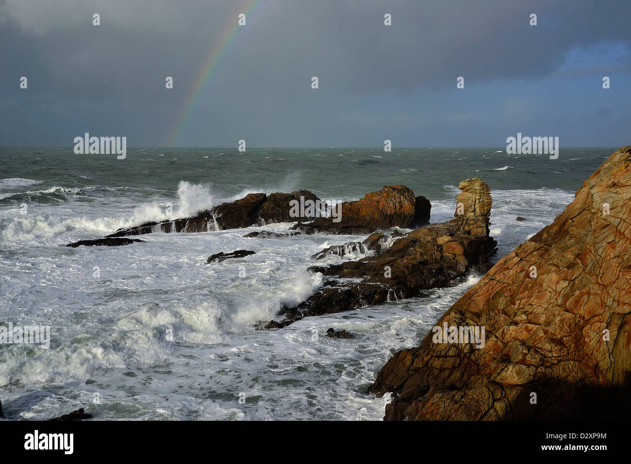 Starker Wellengang im Begriff Beg En Aud, mit einem Regenbogen auf dem Meer, wilde Küste von Quiberon-Halbinsel (Bretagne, Frankreich). Stockfoto