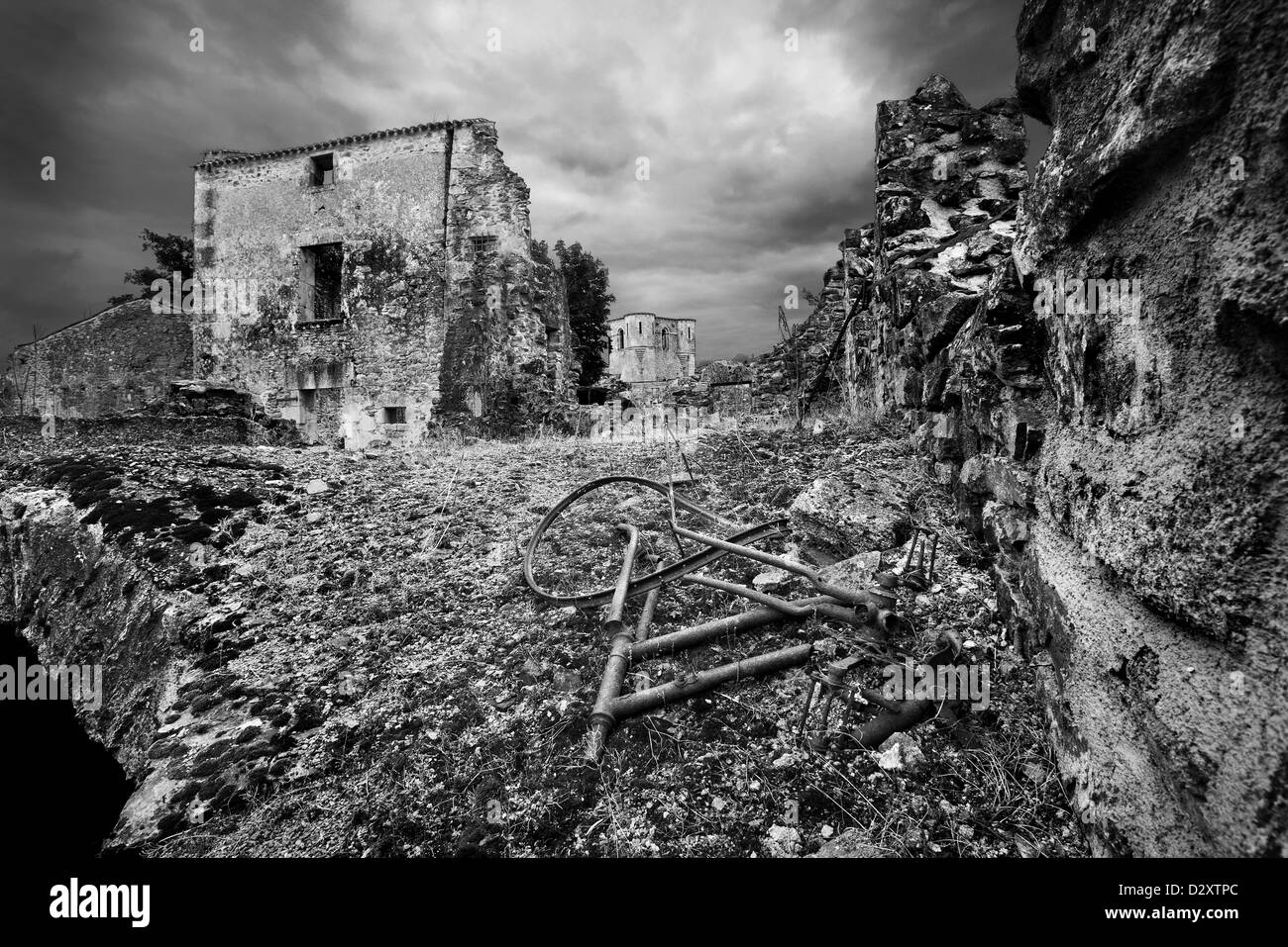 Ein altes Oldtimer Fahrrad liegt auf dem Boden vor einem beschädigten Haus zerstört. Stockfoto