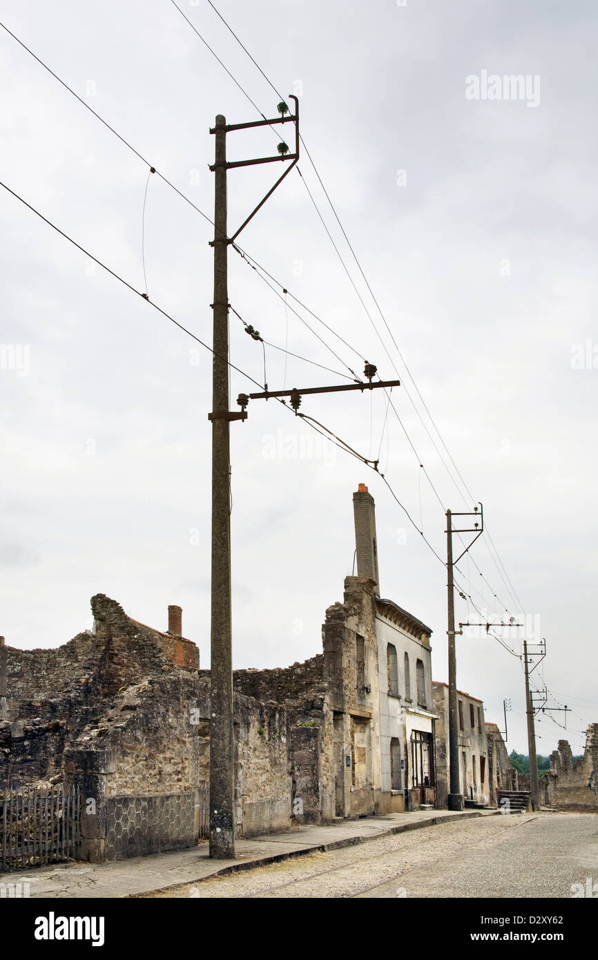 Die Hauptstraße in dem französischen Dorf Oradour-Sur-Glane. Das Dorf wurde In einem Ruined Zustand bewahrt. Stromleitungen und Polen Stockfoto