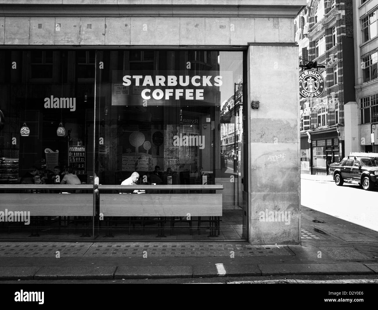 ein Mann sitzt im Starbucks Kaffee in London Stockfoto