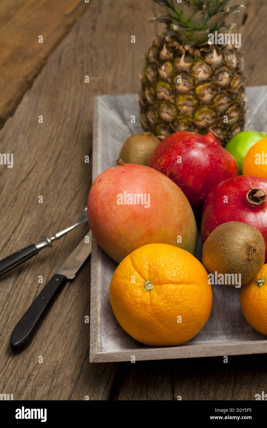 Holzschale mit Früchten und einem Messer mit Gabel auf einem alten Holztisch Stockfoto
