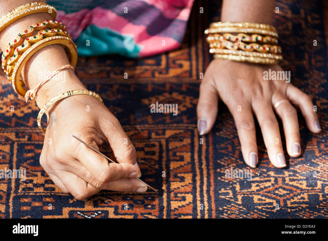 Frauenhand auf Teppich, arbeiten Frauen Handwerk Dorfladen, Ranthambore, Rajasthan, Indien Stockfoto