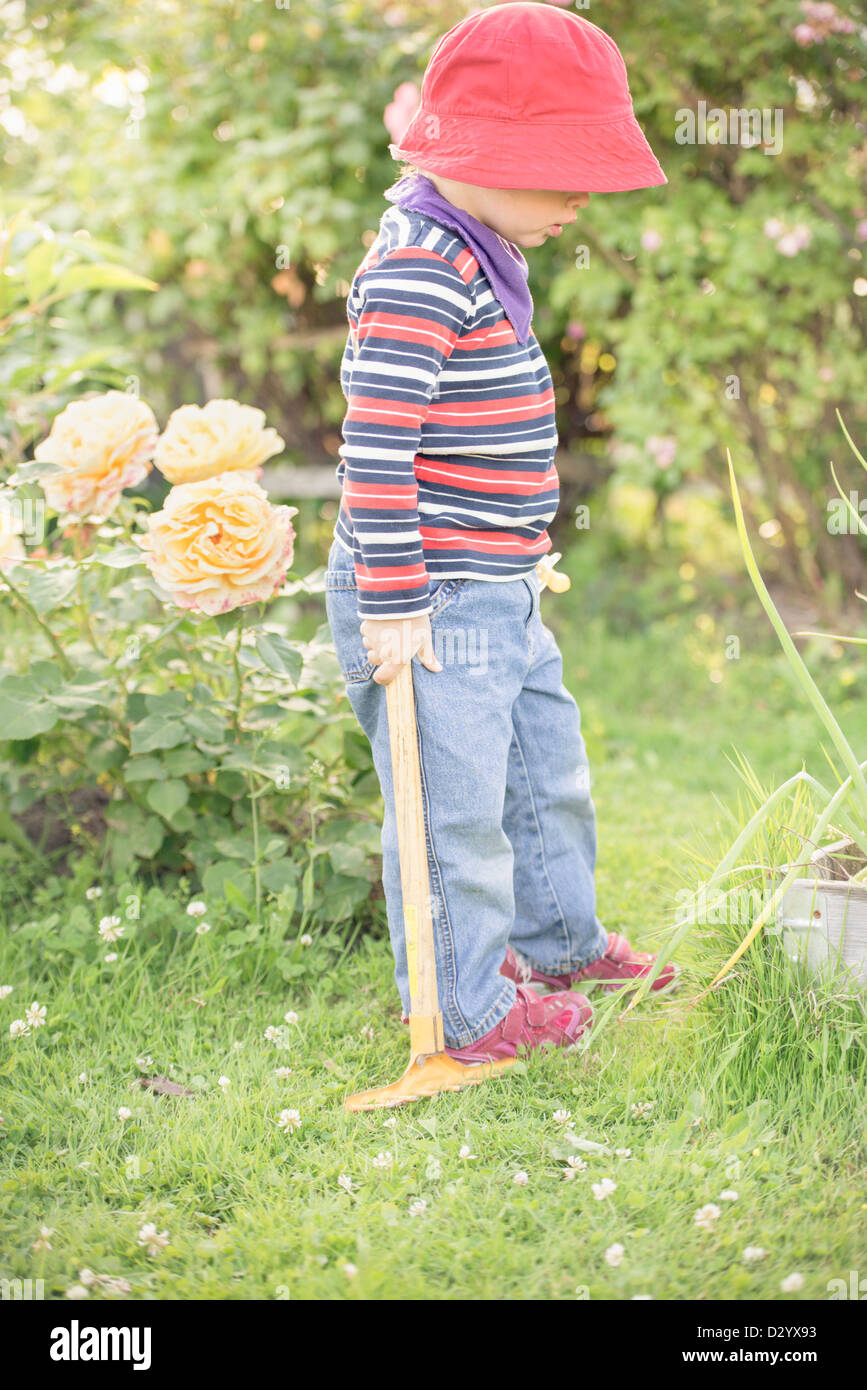 Kleines Kind 3 Jahre alt, in einem Garten spielen und erkunden die Pflanzen, Schweden. Stockfoto