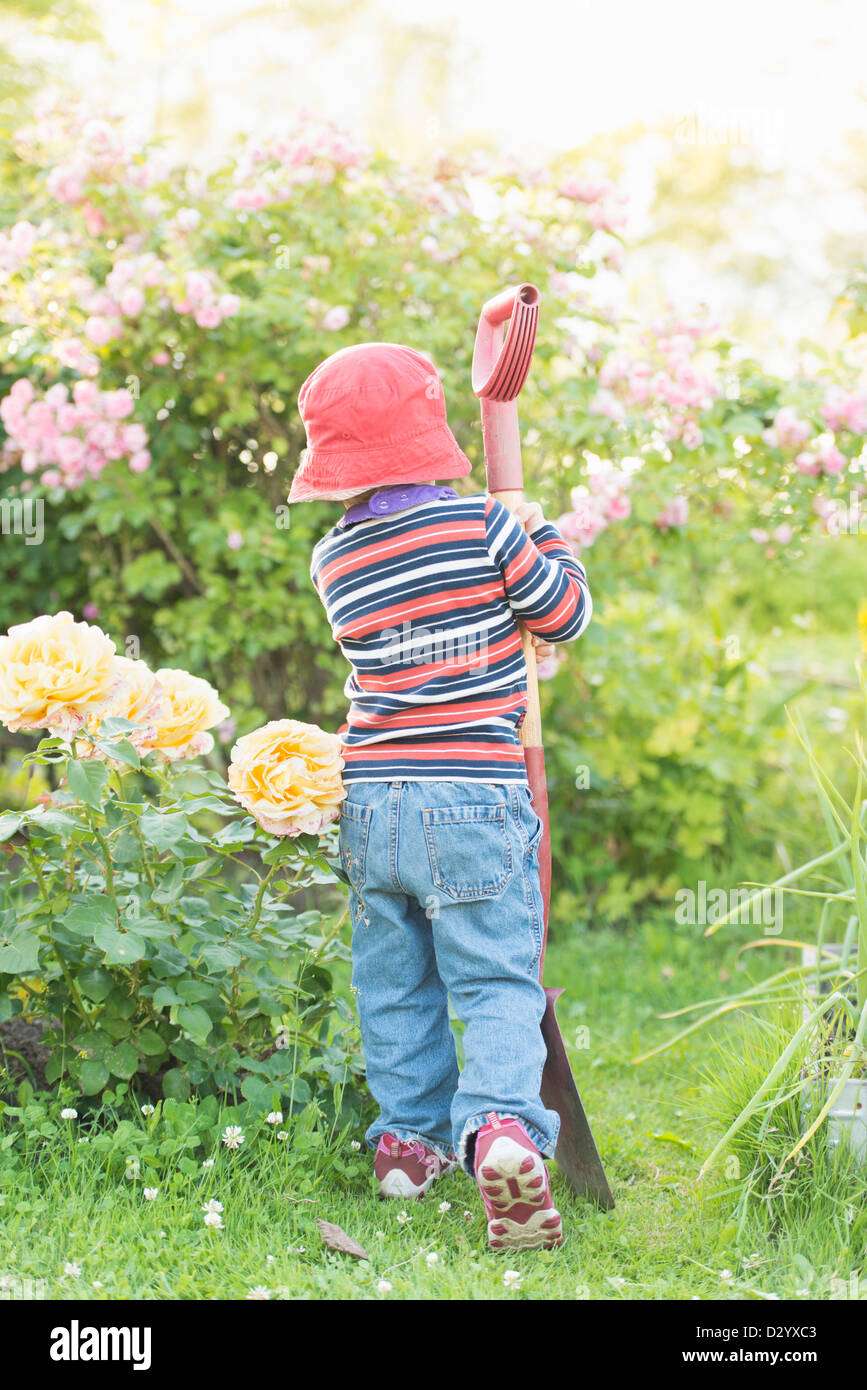Kleines Kind 3 Jahre alt, in einem Garten spielen und erkunden die Pflanzen, Schweden. Stockfoto