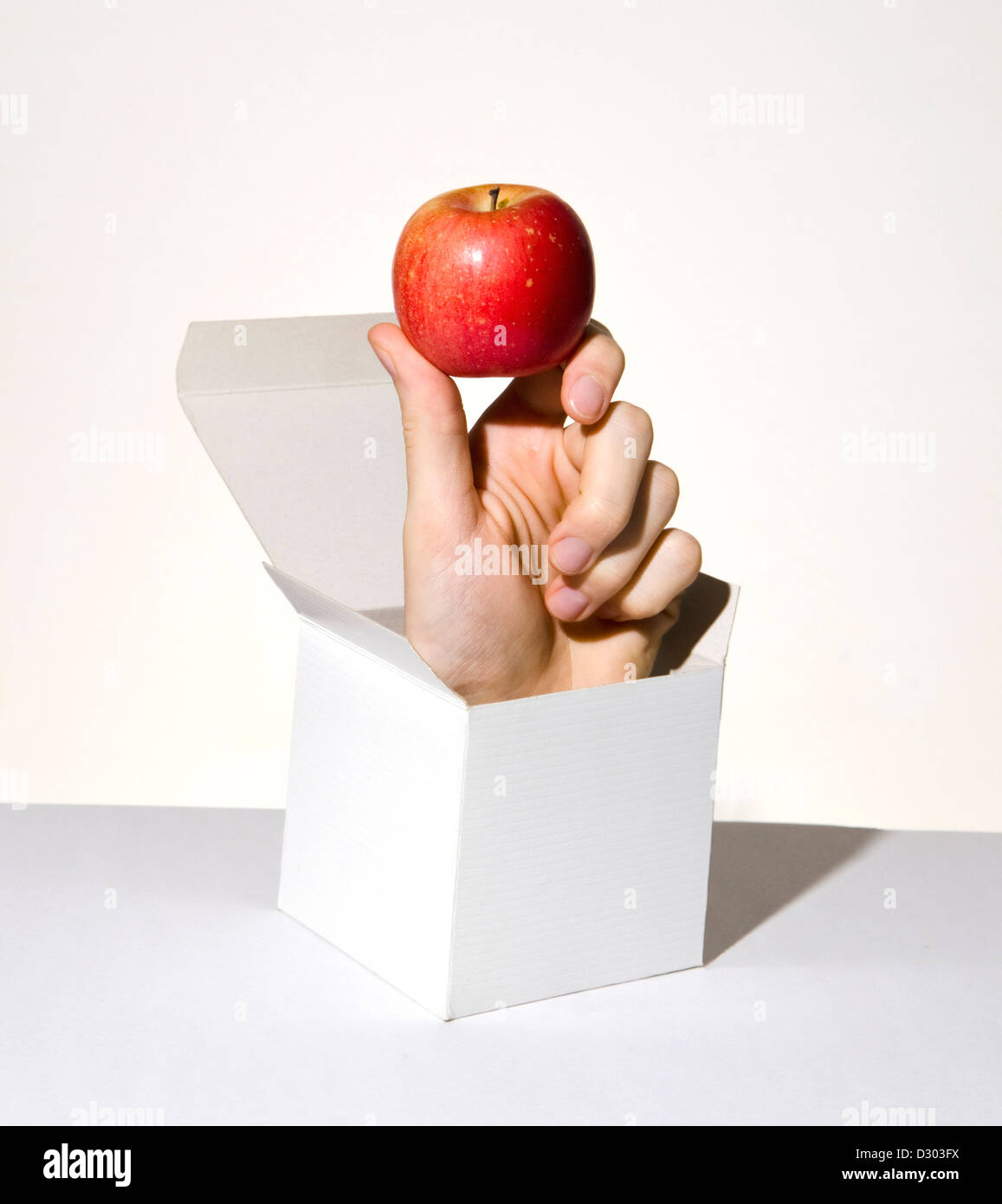 Hand, aufspringen aus Karton mit roter Apfel Stockfoto