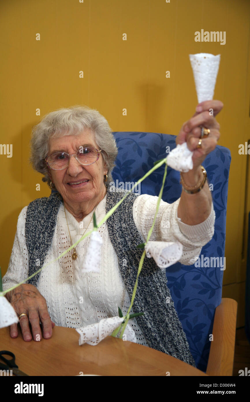 Senioren genießen Handwerk Klasse und hängende Dekoration in ein Gemeindezentrum Stockfoto