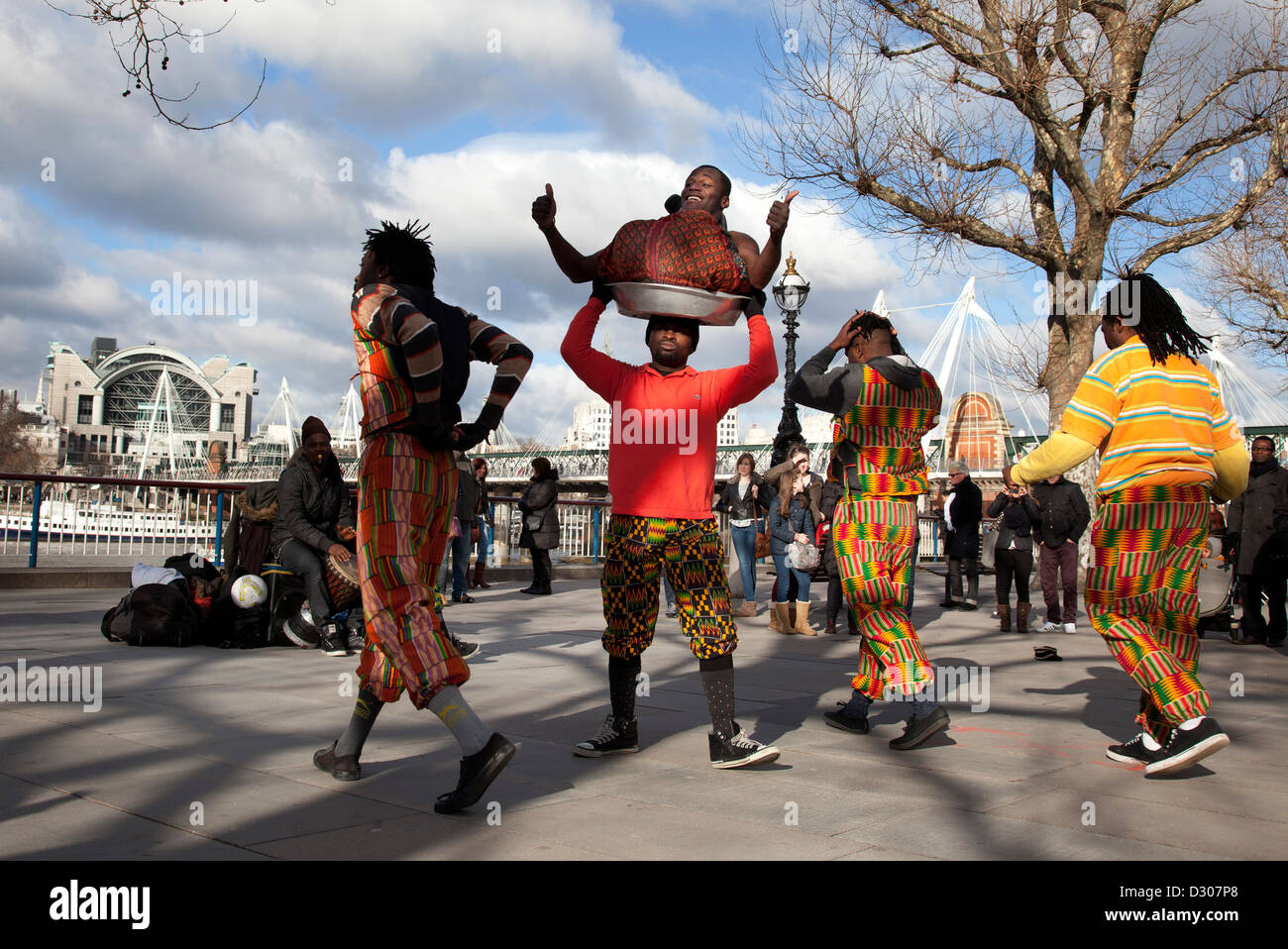 Ein Spaziergang entlang der Themse an der Southbank in London. Afrikanischer Akrobatik Straßenkünstlern durchführen. Stockfoto