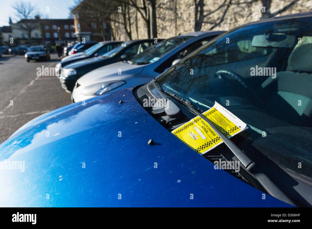 Einen Strafzettel an der Windschutzscheibe des Fahrzeugs auf dem Parkplatz. Stockfoto